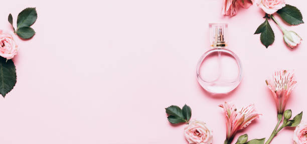 istock Women's perfume bottle and roses flowers on pink background. Banner format with copy space 1226137850