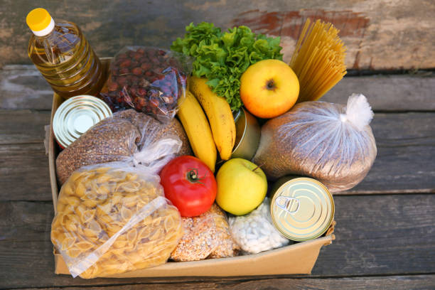 istock Donation box with food on old wooden background. 1226140381