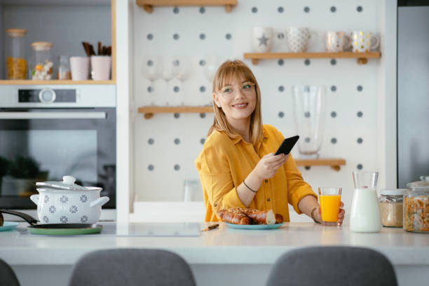 istock Beautiful woman drinking orange juice in the kitchen 1226146677