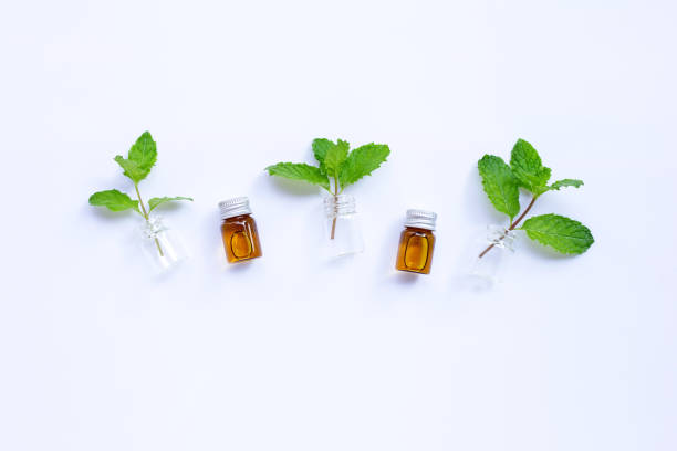 istock Fresh mint leaves with essential oil bottle on white background. 1226147877