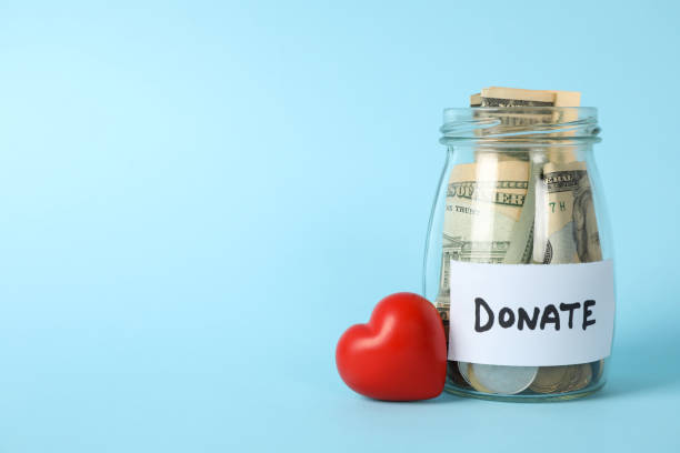 istock Glass jar with text Donate and heart on blue background 1226149833