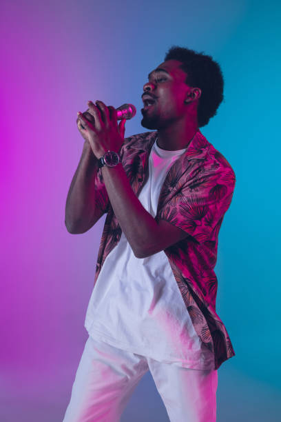 istock African-american male singer portrait isolated on gradient studio background in neon light 1226150030