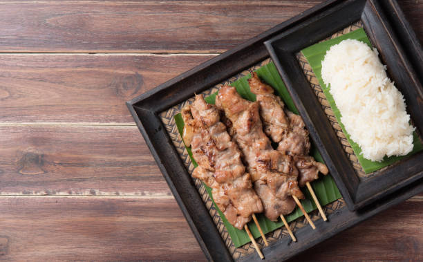 istock Thai styled grilled pork and sticky rice on wood 1226150260