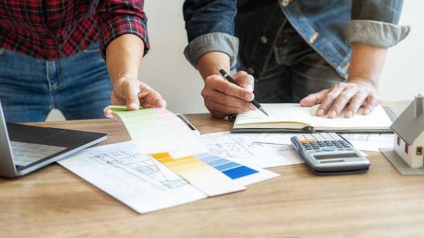 istock Interior designer and Architect choosing color in color swatch samples chart for house coloring selection in office with blueprint. Construction concept. 1226151292