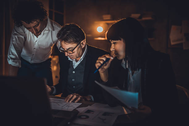 istock Colleagues working late at night in office together 1226151431
