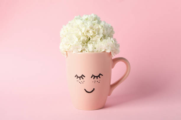 istock Cup with hydrangea flowers on pink background. Spring plant 1226153278