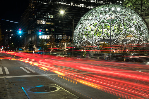 Seattle, USA - Nov 10, 2019: The Amazon Spheres illuminated early in the evening as vehicles pass by.