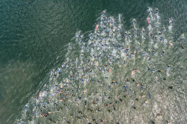 competição de natação de triathlon em nadadores do lago competição foto de drone aéreo - triathlon ironman triathalon ironman people - fotografias e filmes do acervo