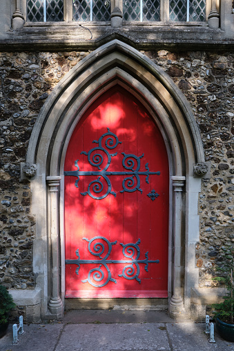 London / UK - May 18, 2020: Close-up of red wooden door at the St. Katherine's Church. The building dates from 1853.