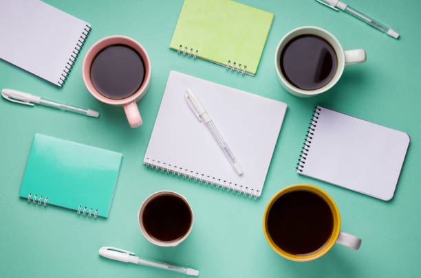 istock working pattern of pens, notebooks and cups of coffee on a mint background 1226164717