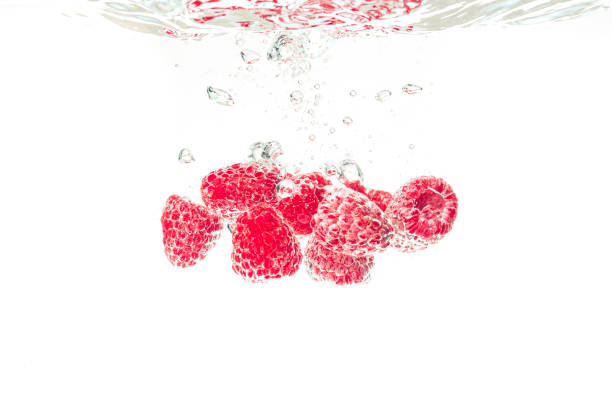 istock Raspberries splashing into crystal clear water with air bubbles 1226172189