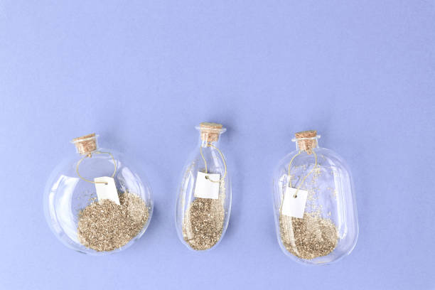 istock Decor, bottles, glitter, dream. Magic background. Beautiful decorative bottles with gold glitter and empty blank for text inside. Top view. Place for your text. 1226173833
