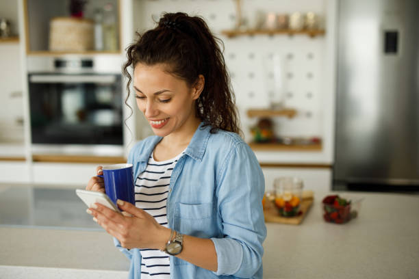 istock Young woman drinking first morning coffee and using smart phone 1226174900