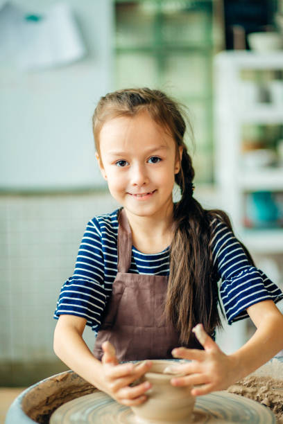 istock Child sculpts from clay pot. modeling on potter wheel. 1226175401