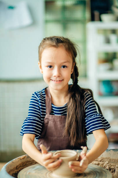 istock Child sculpts from clay pot. modeling on potter wheel. 1226175411