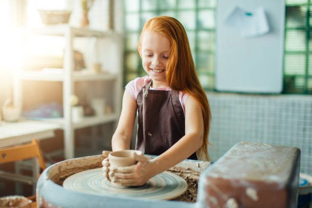 istock redhead Child sculpts from clay pot. workshop on modeling on potter's wheel. 1226175452