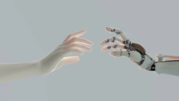 hands of a robot and a man tend to one another