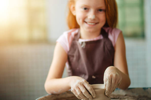 istock redhead Child sculpts from clay pot. workshop on modeling on potter's wheel. 1226175535