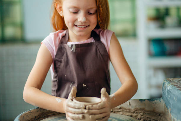 istock redhead Child sculpts from clay pot. workshop on modeling on potter's wheel. 1226175536