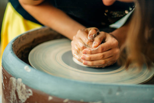 istock Female potter working at throwing wheel at studio. Clay workshop 1226176179