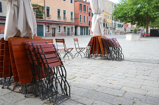 Tables and chairs of an outdoor cafe without tourists due to the quarantine lockdown by Corona Virus in Venice in Italy