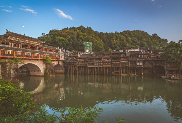 Feng Huang, China -  August 2019 : Morning view of the old historic arched bridge on the riverbanks of Tuo river, flowing through the centre of Fenghuang Old Town