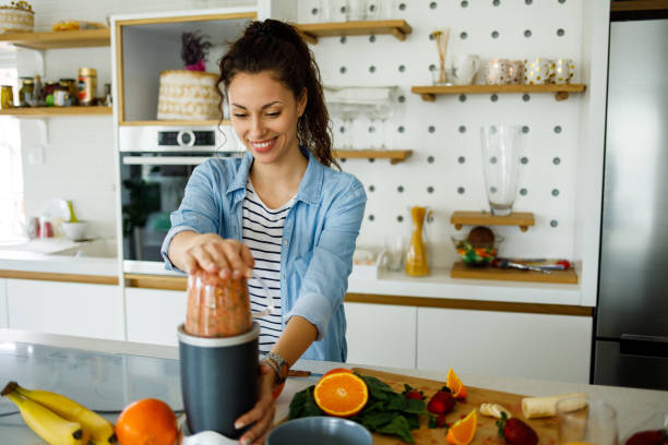 istock Young woman preparing smoothie at home 1226177717