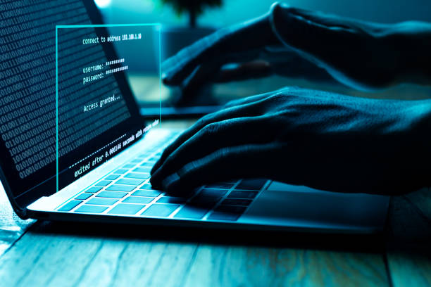 A computer programmer or hacker prints a code on a laptop keyboard to break into a secret organization system. stock photo