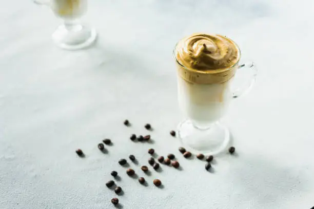 Photo of Dalgona Trend Coffee Korean latte drink with instant coffee foam. Cold fashion trendy drink