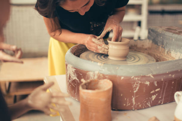 istock Hands of young potter, close up hands made cup on pottery wheel 1226183411