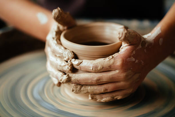 istock Female potter working at throwing wheel at studio. Clay workshop 1226184020