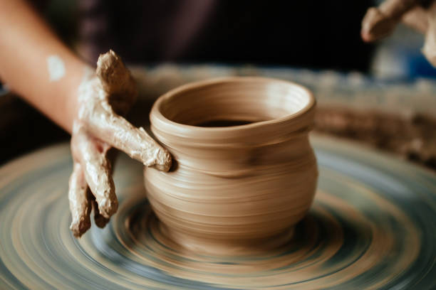 istock Female potter working at throwing wheel at studio. Clay workshop 1226184060