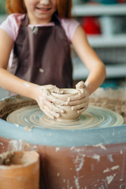 istock Hands of young potter, close up hands made cup on pottery wheel 1226184089