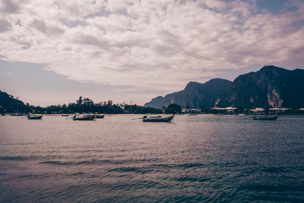 Longtail boats seen in the ocean a cloudy day at Phi Phi Islands in Phuket Krabi, Thailand.