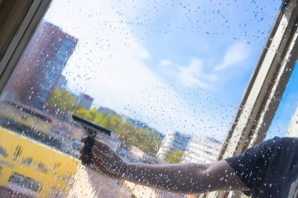 istock Rubber squeegee in male hand cleans a soaped window 1226186332