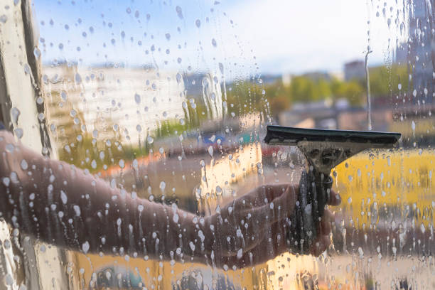 istock Rubber squeegee in male hand cleans a soaped window 1226186381