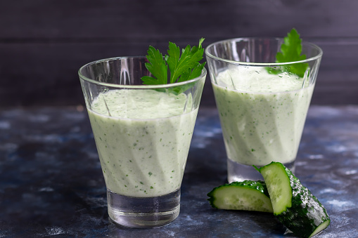 Smoothie with cucumber, parsley and kefir on a dark background. Healthy nutrition, diet.