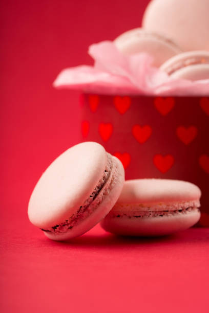 istock Sweet pink macarons present on red background with copy space 1226188292