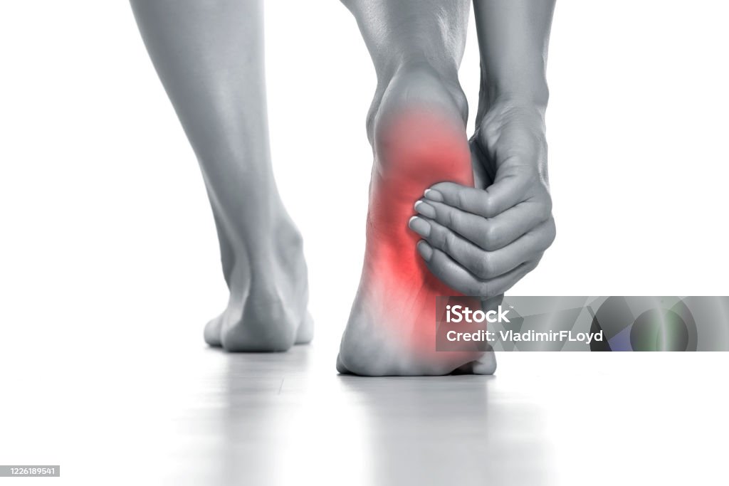 woman holding her painful foot on white woman holding her painful foot on white background Pain Stock Photo