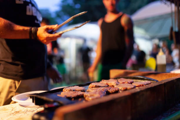 Friends making barbecue in the evening at a party Friends making barbecue in the evening at a party griddle stock pictures, royalty-free photos & images