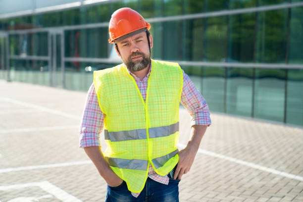istock foreman in vest and protective helmet standing on background of new structure. 1226192752