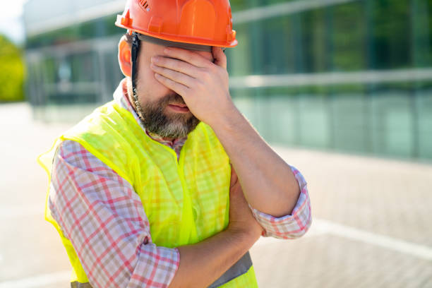 istock upset foreman in vest and protective helmet standing on background of new structure. 1226192805