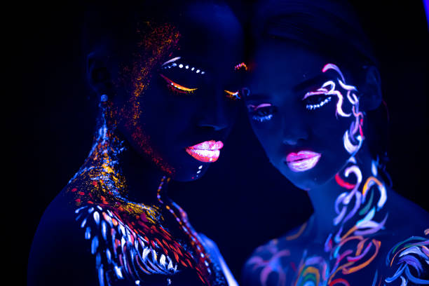 young girls with fluorescent make-up posing at camera