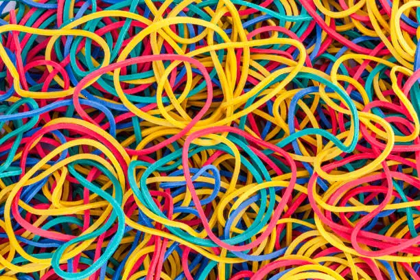 Multicolored bright elastic rubber bands colourful background in a stack heap stock photo