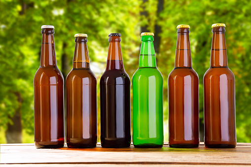 beer on table on blurred park background, summer drinks,many coloured bottles