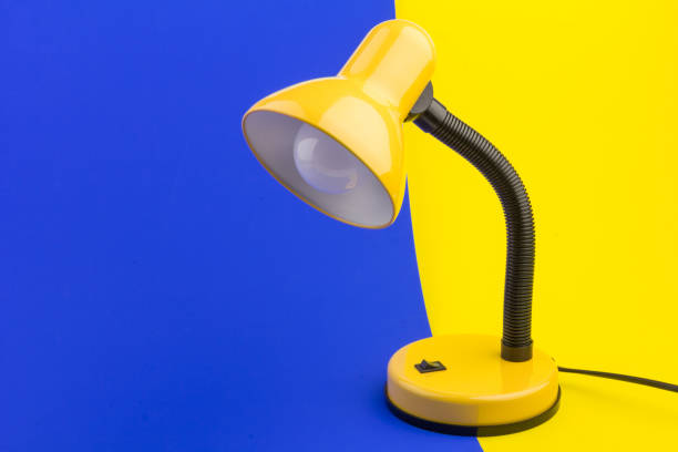 istock Yellow desk lamp isolated on yellow and blue background 1226200072