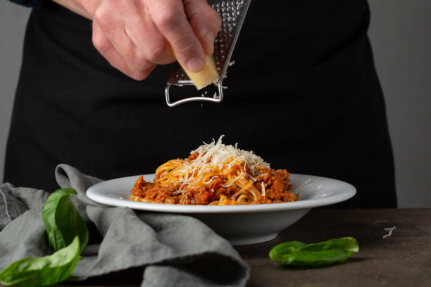 istock Bolognese pasta. Hand grating cheese on spaghetti 1226201401