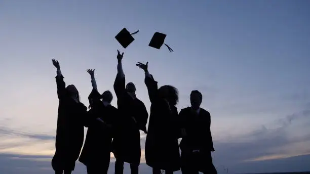 Photo of Silhouette of Graduating Students Throwing Caps In The Air