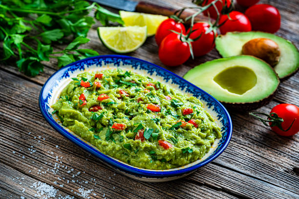 istock Guacamole bowl with ingredients on rustic wooden table 1226202925