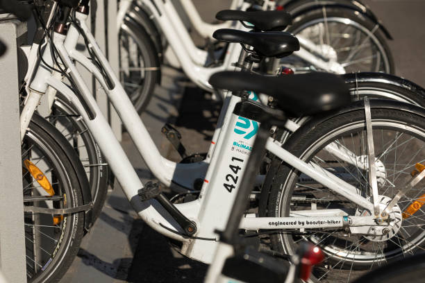 Electric bicycles from the public urban transport service BiciMAD in O'donell Madrid, Spain - May 19, 2020: Electric bicycles from the public urban transport service BiciMAD from the EMT public company, parked in O'donell street. bicycle docking station stock pictures, royalty-free photos & images